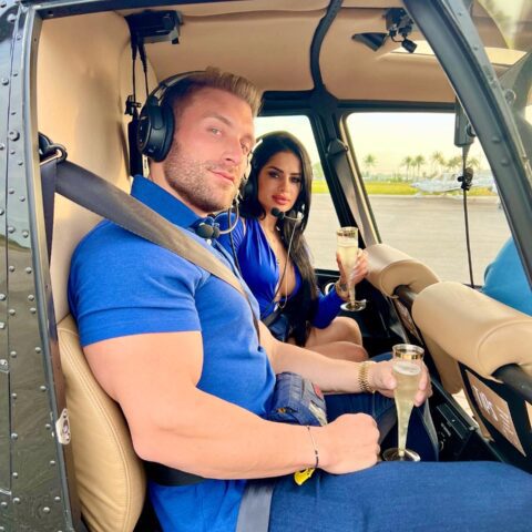 Couple toasting with champagne inside Magic Air Tours helicopter before private romantic flight in Miami