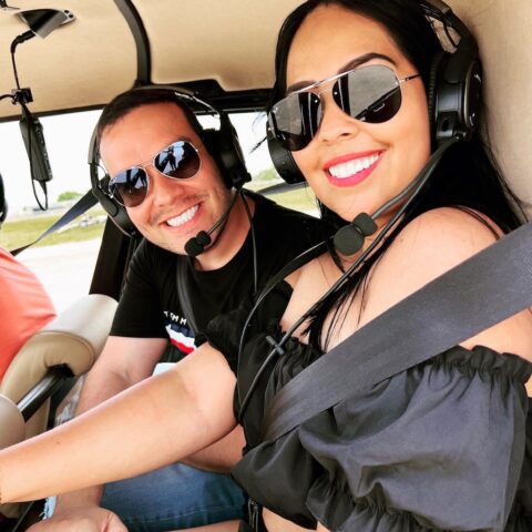 Happy couple inside a Magic Air Tours helicopter preparing for a private Miami helicopter tour