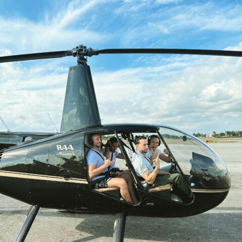 Friends about to take a doors-off helicopter ride over Miami with Magic Air Tours