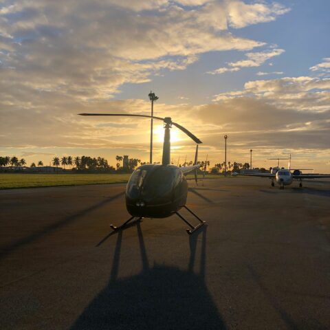 Magic Air Tours helicopter parked at Miami Executive Airport during a vibrant sunset