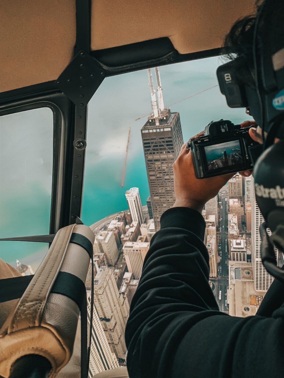 Photographer and videographer capturing aerial shots from a helicopter over Miami for real estate and wildlife projects.
